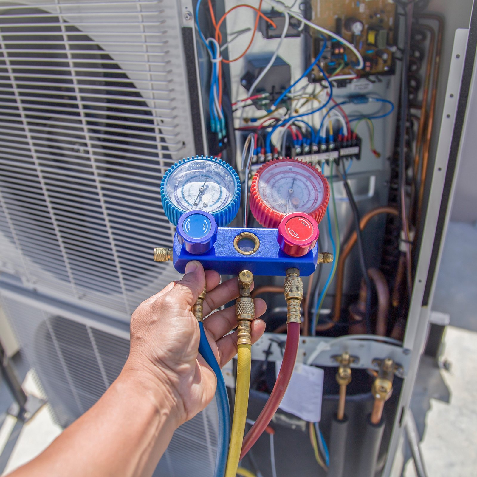 Technician checking heat pump refrigerant levels.
